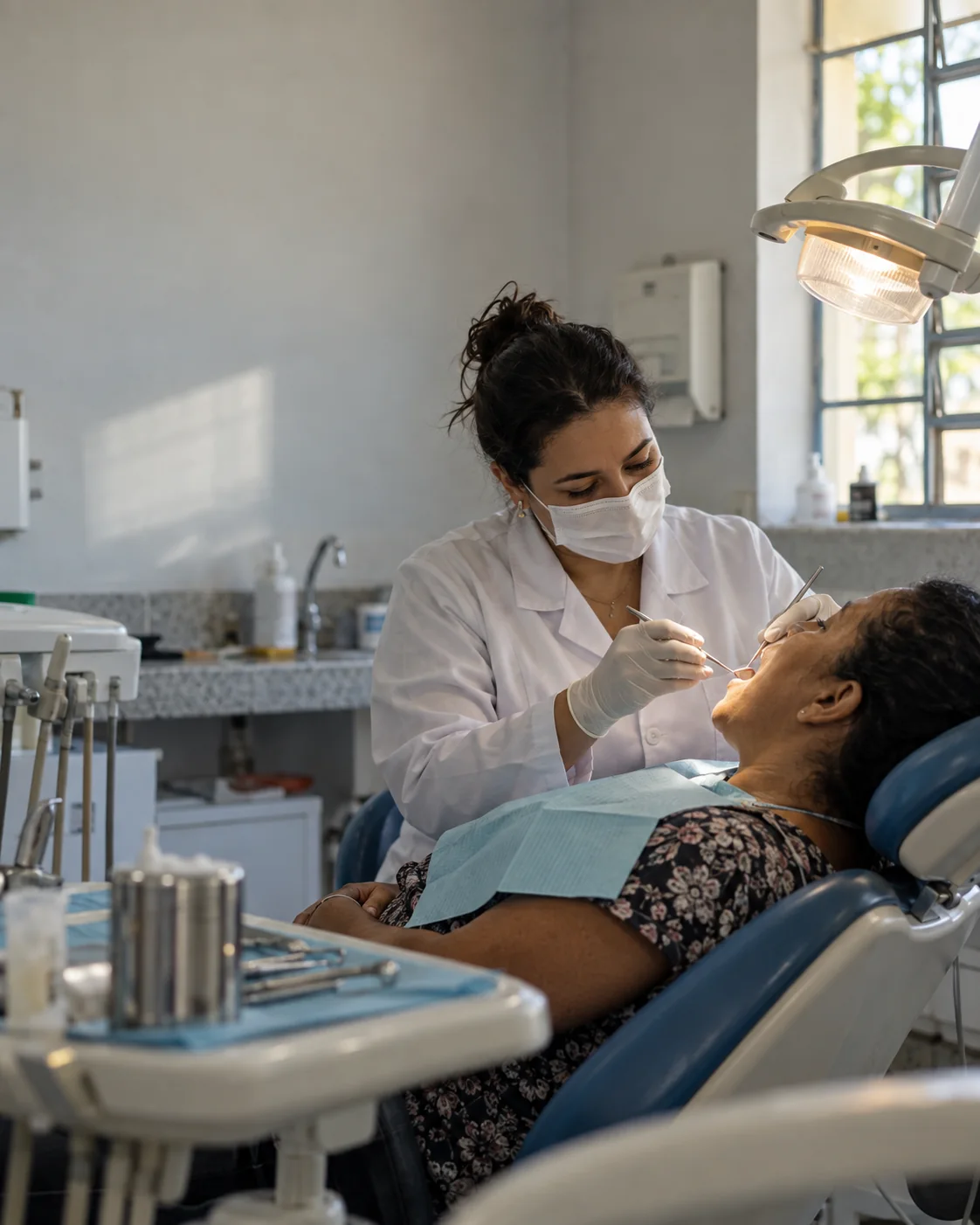 Ilustração fotográfica de uma dentista atendendo um adulto numa clínica pública