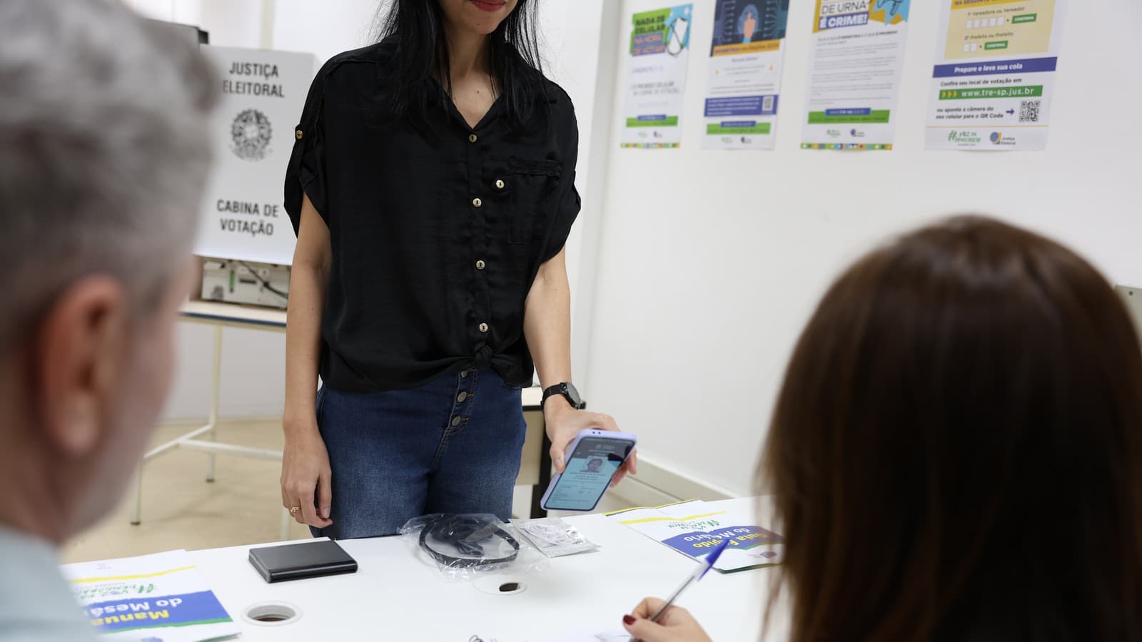 Eleitora apresenta documento digital em uma seção eleitoral